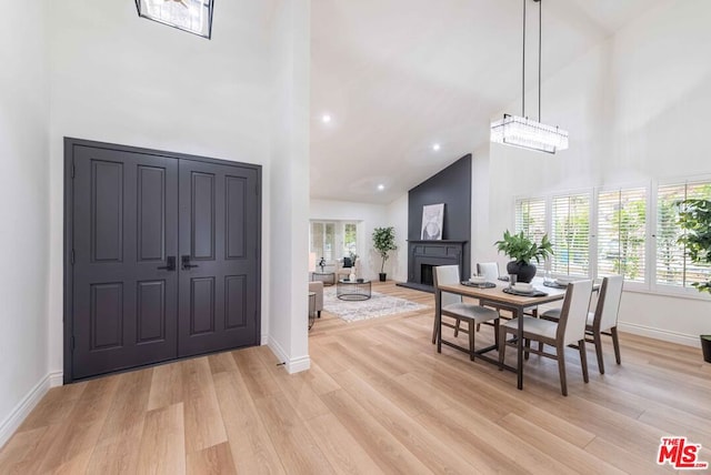 dining space featuring a towering ceiling and light hardwood / wood-style floors