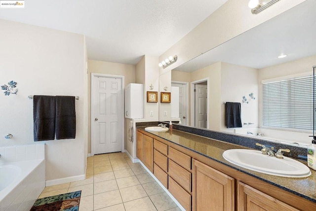 bathroom featuring tile patterned flooring, vanity, and tiled bath