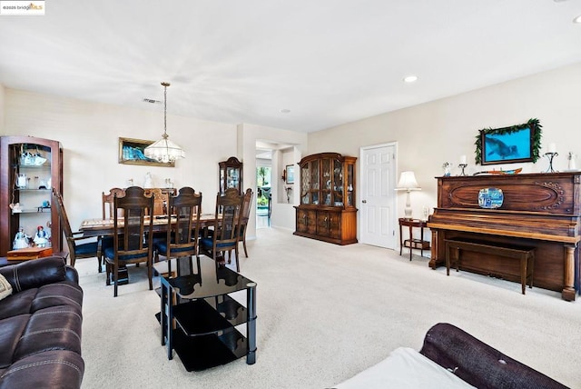 living room featuring light colored carpet and a notable chandelier