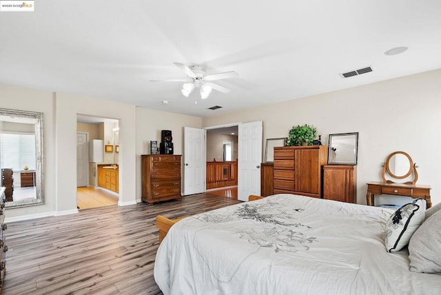 bedroom with light hardwood / wood-style floors, ceiling fan, and ensuite bathroom