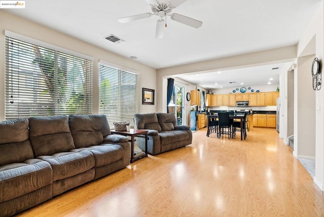 living room with ceiling fan and light hardwood / wood-style floors