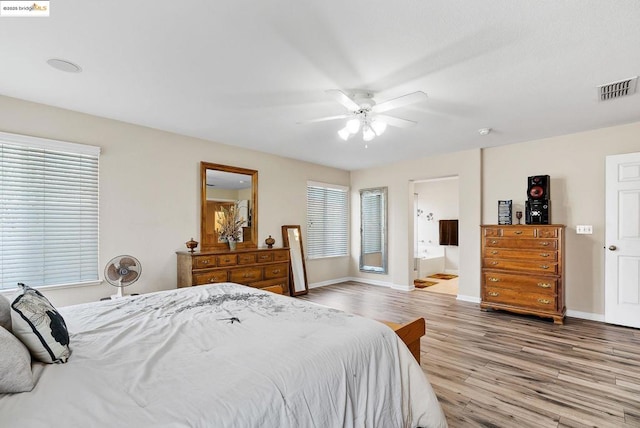 bedroom with ceiling fan, connected bathroom, and hardwood / wood-style floors