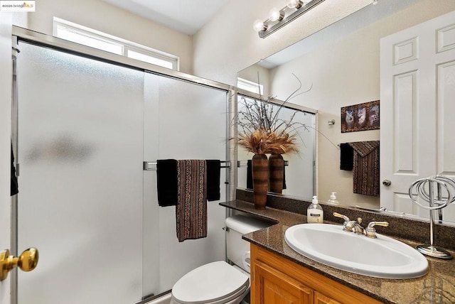 bathroom with vanity, toilet, and an enclosed shower