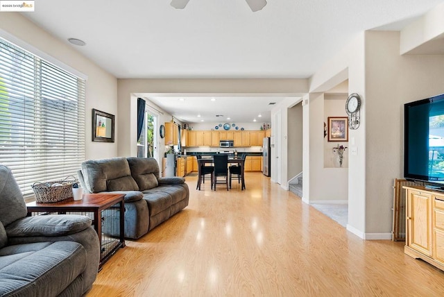 living room featuring ceiling fan and light hardwood / wood-style floors