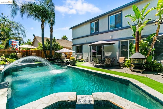 view of swimming pool with pool water feature and a patio