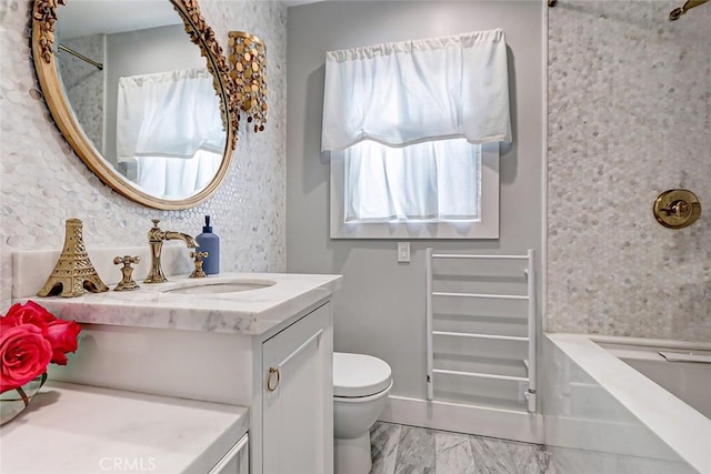 bathroom featuring vanity, plenty of natural light, and toilet