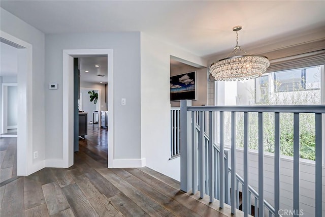 hall featuring dark hardwood / wood-style flooring and a notable chandelier