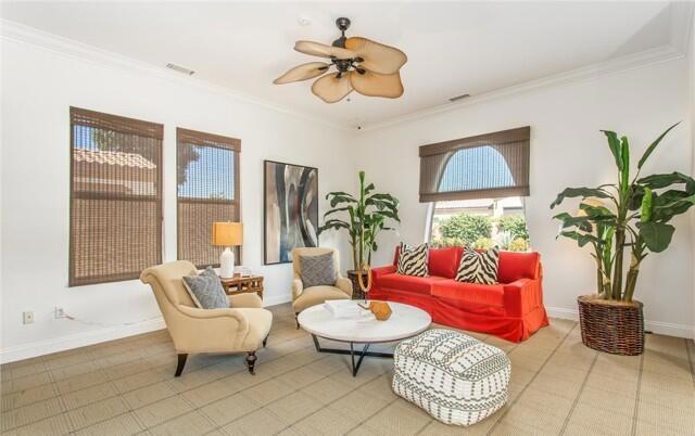 living area featuring crown molding and ceiling fan