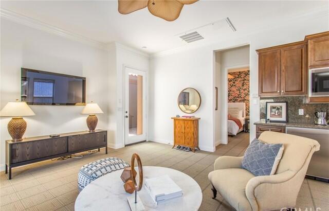 living room featuring crown molding and ceiling fan