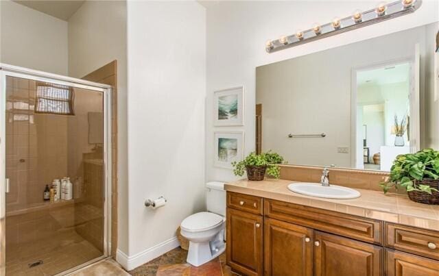 bathroom featuring vanity, a shower with door, and toilet