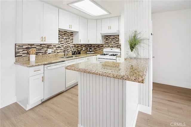 kitchen with white cabinetry, sink, light stone counters, white appliances, and light hardwood / wood-style flooring