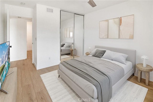 bedroom with wood-type flooring, a closet, and ceiling fan