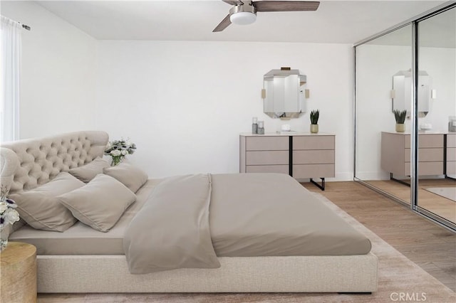 bedroom with a closet, ceiling fan, and light wood-type flooring