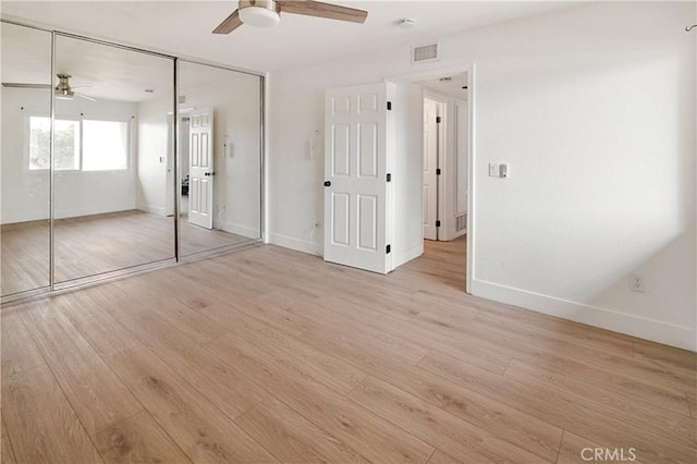 unfurnished bedroom with ceiling fan, a closet, and light wood-type flooring