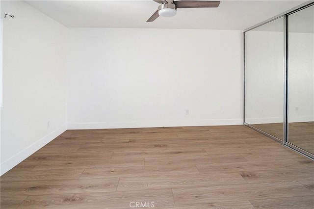 interior space with ceiling fan, light wood-type flooring, and a closet