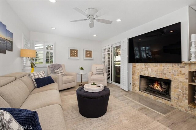 living room featuring light hardwood / wood-style flooring and ceiling fan