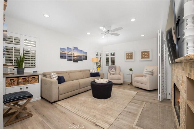 living room with ceiling fan and light hardwood / wood-style floors