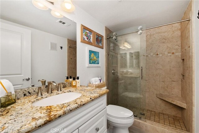 bathroom with vanity, an enclosed shower, and toilet