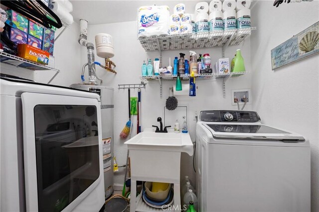 laundry area with separate washer and dryer and sink