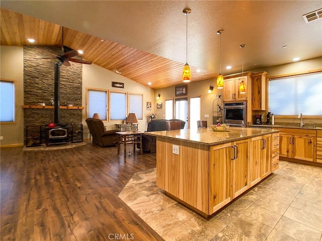 kitchen with stone counters, lofted ceiling, hanging light fixtures, a center island, and wooden ceiling