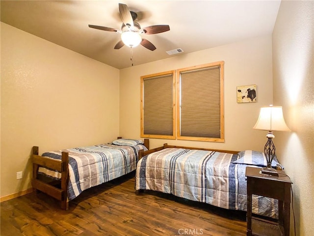 bedroom with dark hardwood / wood-style flooring and ceiling fan