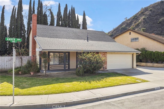 view of front facade featuring a garage, a mountain view, and a front yard