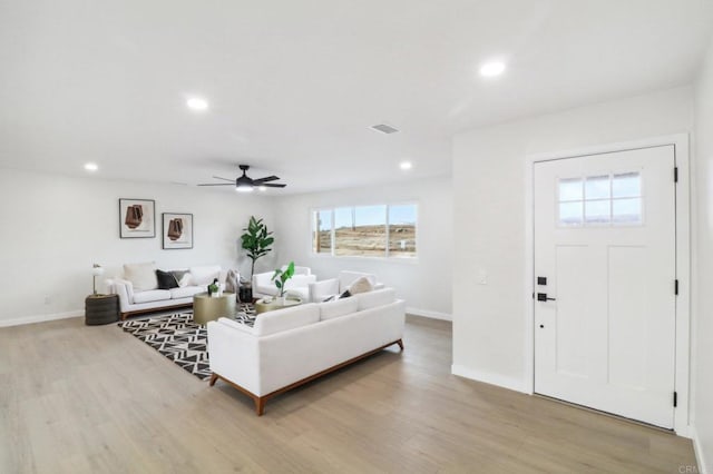 living room with ceiling fan and light hardwood / wood-style flooring