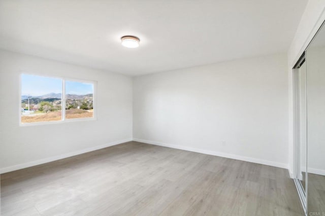 unfurnished bedroom featuring a closet and light wood-type flooring