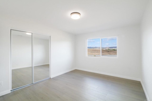 unfurnished bedroom with a closet and light wood-type flooring