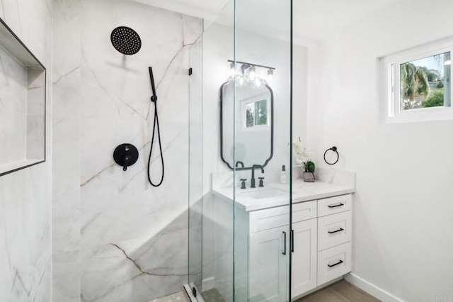 bathroom featuring vanity, hardwood / wood-style flooring, plenty of natural light, and a tile shower