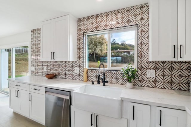 kitchen featuring white cabinetry, dishwasher, sink, backsplash, and light stone counters