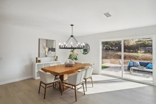 dining area with an inviting chandelier and wood-type flooring