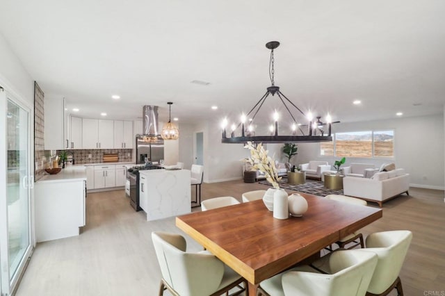 dining room with a chandelier and light wood-type flooring