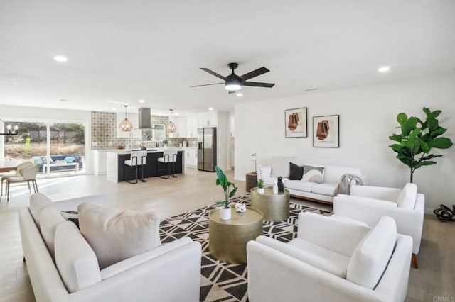 living room with ceiling fan and light wood-type flooring