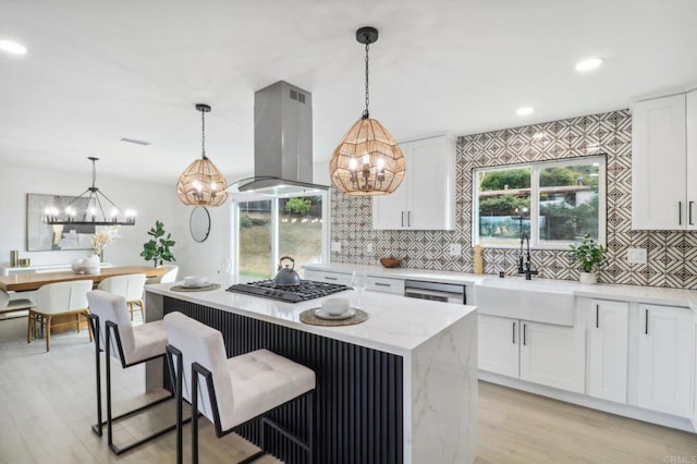 kitchen featuring sink, appliances with stainless steel finishes, white cabinets, and island exhaust hood