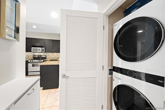 washroom featuring light tile patterned floors, sink, and stacked washer and clothes dryer