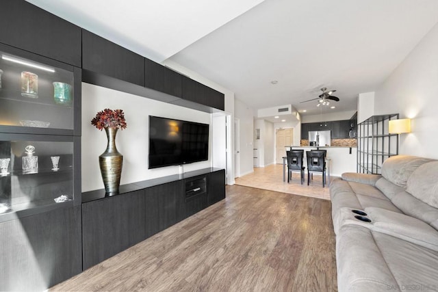 living room featuring hardwood / wood-style floors and ceiling fan