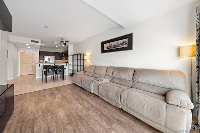 living room with light hardwood / wood-style flooring and ceiling fan