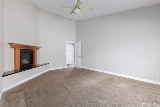 unfurnished living room with high vaulted ceiling, carpet flooring, and ceiling fan