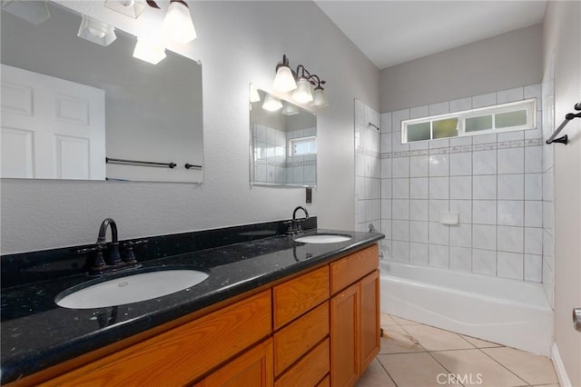 bathroom with tile patterned flooring, tiled shower / bath, and vanity