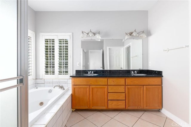 bathroom featuring tile patterned flooring, vanity, and tiled bath