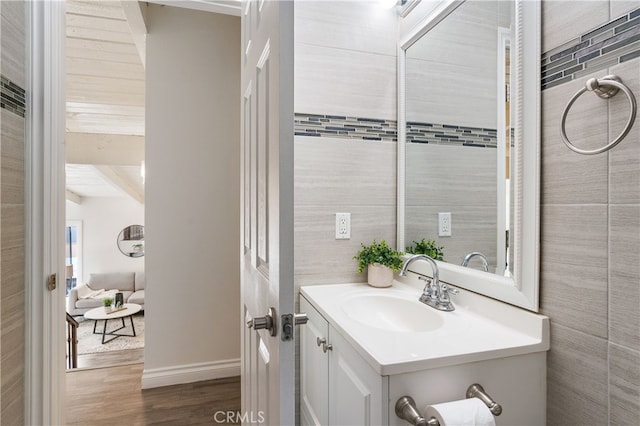 bathroom featuring vanity, hardwood / wood-style floors, and beamed ceiling