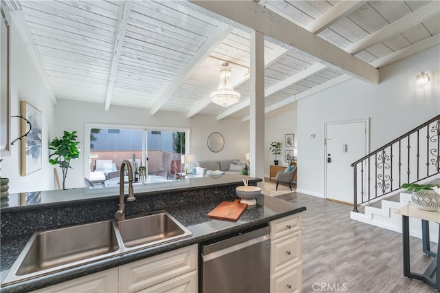 kitchen featuring decorative light fixtures, white cabinetry, sink, stainless steel dishwasher, and light wood-type flooring