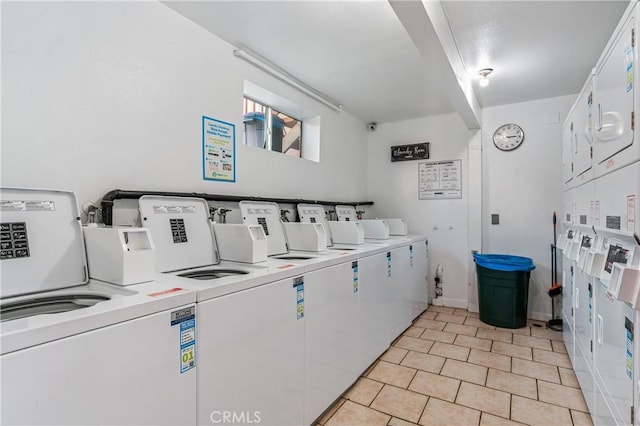 laundry area featuring stacked washer and clothes dryer, independent washer and dryer, and light tile patterned flooring