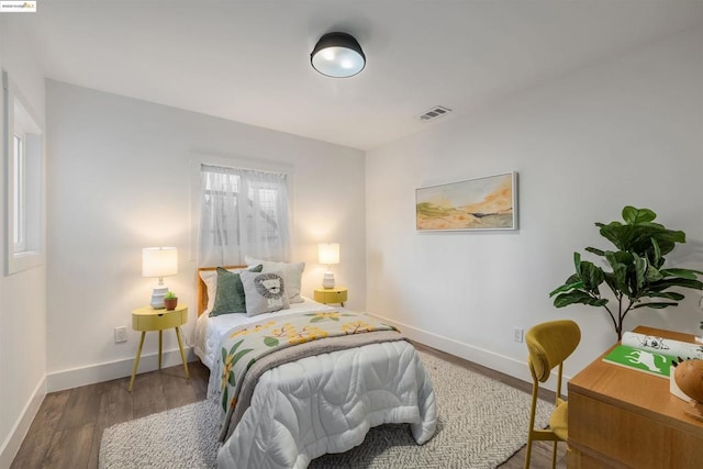 bedroom with dark hardwood / wood-style flooring