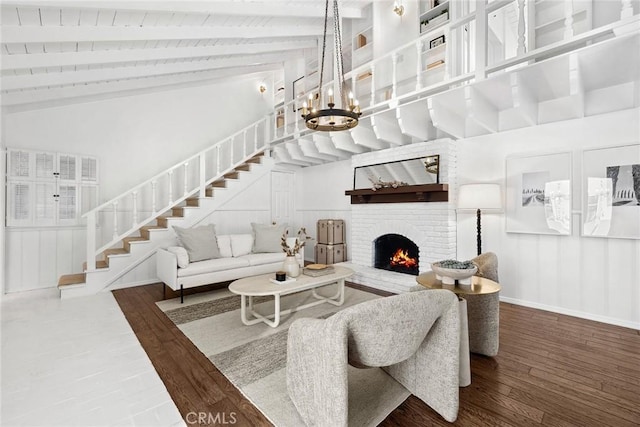 living room with dark hardwood / wood-style floors, high vaulted ceiling, beamed ceiling, a notable chandelier, and a brick fireplace