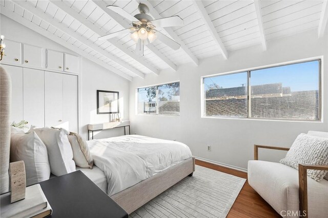 bedroom with wood ceiling, ceiling fan, lofted ceiling with beams, dark hardwood / wood-style flooring, and a closet