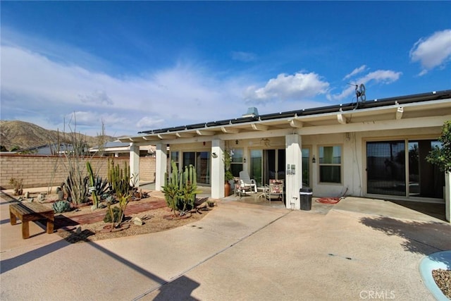 rear view of house with a mountain view and a patio