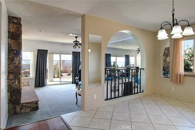 interior space featuring a textured ceiling, light colored carpet, and ceiling fan