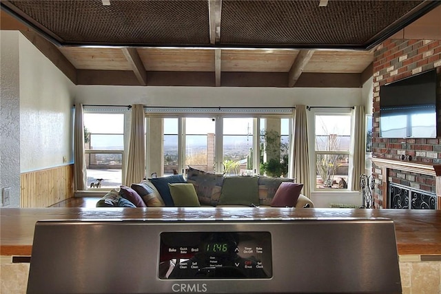 living room featuring wood ceiling, beam ceiling, and a fireplace